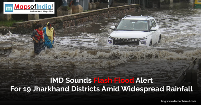 Image showing a flooded street in Jharkhand with pedestrians wading through water and a car navigating the waterlogged road.