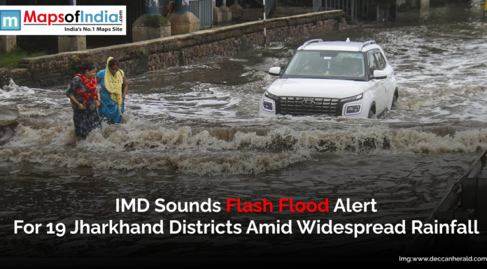 IMD sounds flash flood alert for 19 Jharkhand districts amid widespread rainfall Image showing a flooded street in Jharkhand with pedestrians wading through water and a car navigating the waterlogged road.