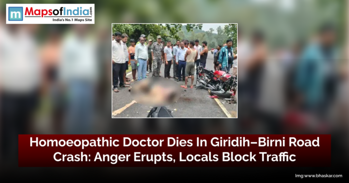 Crowd gathers at the site of a fatal road accident on Giridih–Birni Road in Jharkhand, where a homoeopathic doctor lost his life; damaged motorcycle and victim's body seen on the road.