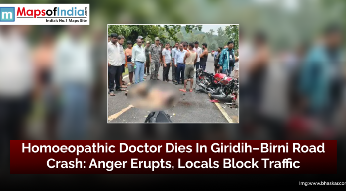 Homoeopathic Doctor Dies in Giridih–Birni Road Crash: Anger Erupts, Locals Block Traffic Crowd gathers at the site of a fatal road accident on Giridih–Birni Road in Jharkhand, where a homoeopathic doctor lost his life; damaged motorcycle and victim's body seen on the road.