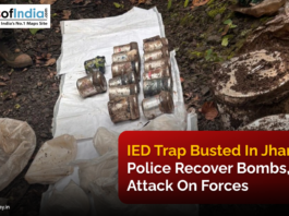 Recovered IEDs and explosive materials laid out on a plastic sheet in a forested area in Jharkhand, with police personnel standing nearby after foiling a planned attack.