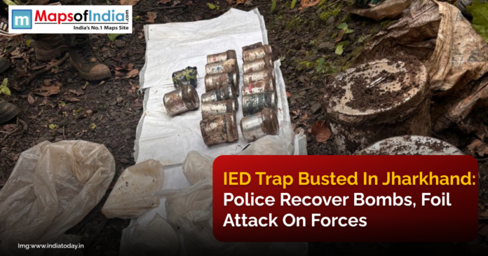 Recovered IEDs and explosive materials laid out on a plastic sheet in a forested area in Jharkhand, with police personnel standing nearby after foiling a planned attack.
