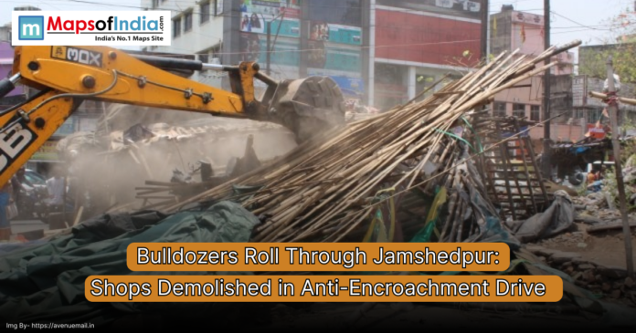 A bulldozer demolishing roadside structures during an anti-encroachment drive in Jamshedpur, with debris and makeshift shops in the background.