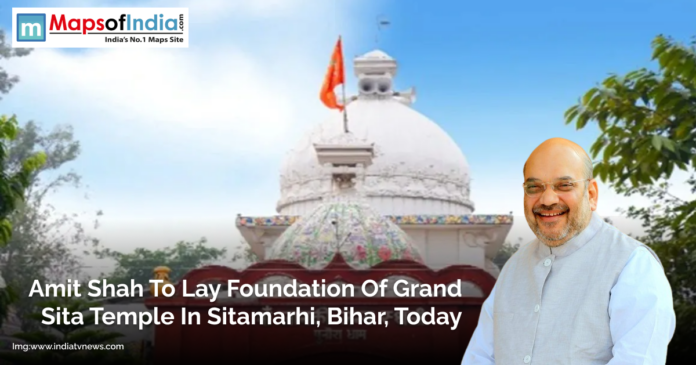 Amit Shah smiling in front of a white temple dome with an orange flag, representing the foundation laying ceremony of the Grand Sita Temple in Sitamarhi, Bihar.