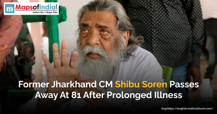 Former Jharkhand Chief Minister Shibu Soren, with long white hair and beard, seen raising his hand while seated.