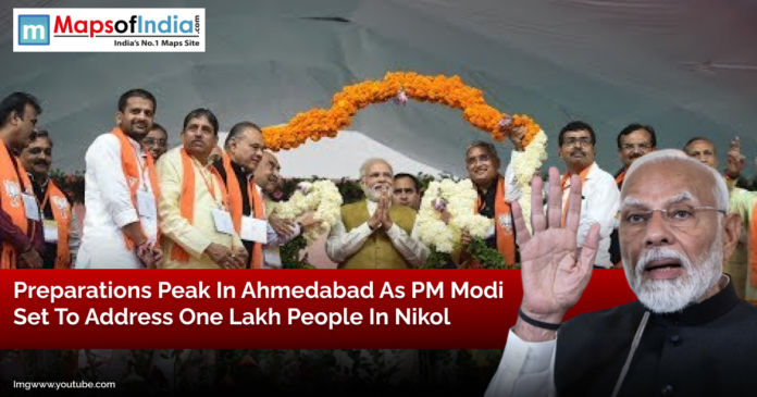 Prime Minister Narendra Modi addressing a gathering in Ahmedabad with BJP leaders on stage, decorated with flower garlands, ahead of a massive public rally in Nikol.