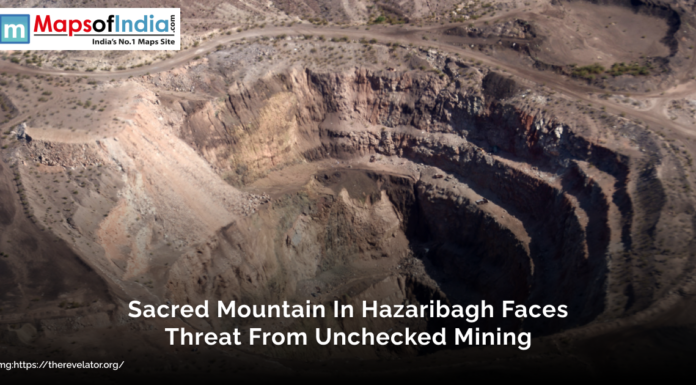 Sacred Mountain in Hazaribagh Faces Threat from Unchecked Mining Aerial view of a large mining site cutting into a mountain in Hazaribagh, illustrating environmental degradation with the text overlay “Sacred Mountain In Hazaribagh Faces Threat From Unchecked Mining”