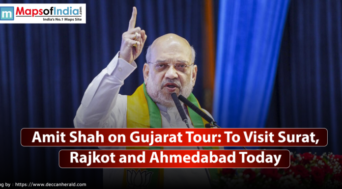 Amit Shah on Gujarat Tour: To Visit Surat, Rajkot and Ahmedabad Today Image of Amit Shah speaking at a podium with a raised finger, wearing glasses and a green and yellow scarf, with text overlay stating "Amit Shah on Gujarat Tour: To Visit Surat, Rajkot and Ahmedabad Today."