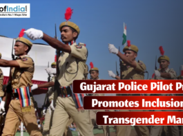 A group of uniformed Gujarat police officers, wearing beige uniforms with red plumes on their hats, march in formation during a parade, with the Indian flag visible in the background.