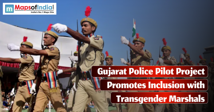 A group of uniformed Gujarat police officers, wearing beige uniforms with red plumes on their hats, march in formation during a parade, with the Indian flag visible in the background.