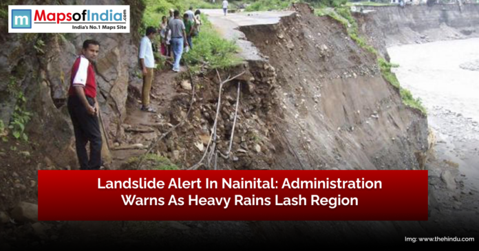 Landslide-affected road in Nainital with people standing nearby, as administration issues warning after heavy rains.