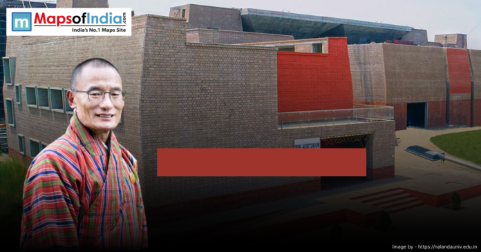 A person in traditional attire stands in front of a modern brick building labeled 