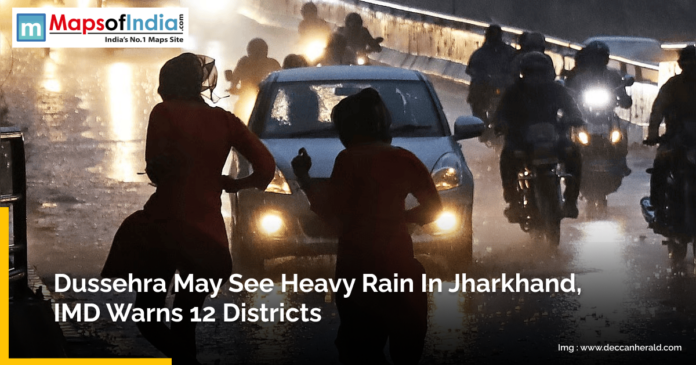 People walk and ride motorcycles on a wet road during heavy rain in Jharkhand, with vehicles' headlights on in low visibility. A news alert from Maps of India reports that the IMD has warned of heavy rainfall in 12 districts of Jharkhand during Dussehra.
