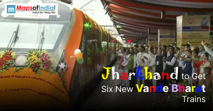 Framjharkhand to get six new vande bharat Image showing a decorated Vande Bharat Express train at a railway station with a crowd gathered to celebrate its launch, accompanied by the text “Jharkhand to Get Six New Vande Bharat Trains.”