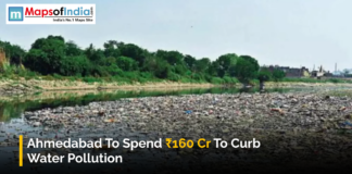 Ahmedabad to Spend ₹160 Cr to Curb Water Pollution A polluted river in Ahmedabad filled with waste, with trees and buildings visible in the background.