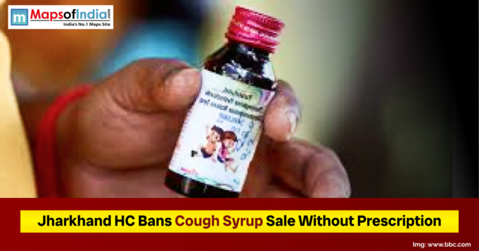 A close-up of a person holding a small cough syrup bottle, accompanied by a headline stating that the Jharkhand High Court has banned the sale of cough syrup without a prescription.