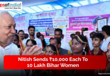 Nitish Sends ₹10,000 Each to 10 Lakh Bihar Women A senior official interacts with a group of women dressed in traditional attire at a public event, with banners displayed in the background.