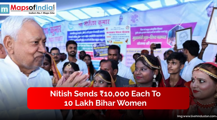 Nitish Sends ₹10,000 Each to 10 Lakh Bihar Women A senior official interacts with a group of women dressed in traditional attire at a public event, with banners displayed in the background.