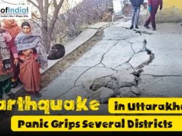 People stand near a cracked and damaged road after an earthquake in Uttarakhand, showing visible destruction and concern among residents in affected districts.