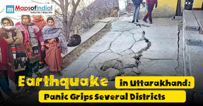 People stand near a cracked and damaged road after an earthquake in Uttarakhand, showing visible destruction and concern among residents in affected districts.