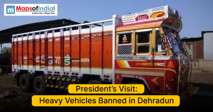 Colorful Indian truck parked on a road with text announcing a ban on heavy vehicles in Dehradun during the President’s visit.