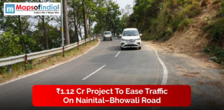 ₹1.12 Cr Project to Ease Traffic on Nainital–Bhowali Road A view of vehicles driving along the curved Nainital–Bhowali road surrounded by trees, highlighting the ₹1.12 crore project aimed at easing traffic in the hilly region.