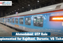 Ahmedabad: OTP Rule Implemented for Rajdhani, Duronto, VB Tickets A blue and grey train (Rajdhani Express) car at a station platform, with a text overlay reading: "Ahmedabad: OTP Rule Implemented for Rajdhani, Duronto, VB Tickets".