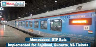 Ahmedabad: OTP Rule Implemented for Rajdhani, Duronto, VB Tickets A blue and grey train (Rajdhani Express) car at a station platform, with a text overlay reading: "Ahmedabad: OTP Rule Implemented for Rajdhani, Duronto, VB Tickets".
