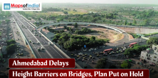 Ahmedabad Delays Height Barriers on Bridges, Plan Put on Hold Aerial view of a busy Ahmedabad flyover and road junction with vehicles in motion, featuring a headline reading “Ahmedabad Delays Height Barriers on Bridges, Plan Put on Hold” and the Maps of India logo.