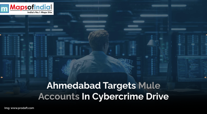 Ahmedabad Targets Mule Accounts in Cybercrime Drive A person sits at a desk in a dimly lit room surrounded by large computer monitors displaying data and code, representing cybersecurity operations. A headline overlay mentions Ahmedabad’s action against mule accounts in a cybercrime drive.