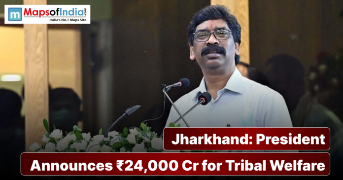 President Droupadi Murmu addressing a gathering in Jharkhand, announcing ₹24,000 crore for tribal welfare, with podium and microphones visible.