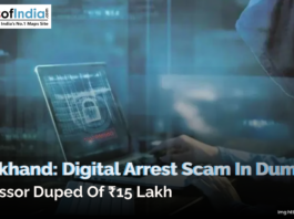 A person sitting in a hooded outfit holding a laptop