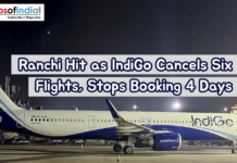 Ranchi Hit as IndiGo Cancels Six Flights, Stops Booking 4 Days An IndiGo aircraft parked on an airport tarmac at night, illuminated by runway lights. A headline overlay reports flight cancellations and halted bookings in Ranchi.
