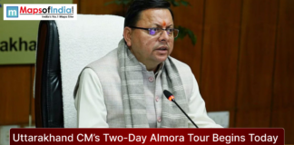 Uttarakhand CM’s Two-Day Almora Tour Begins Today Uttarakhand Chief Minister seated at a desk during an official meeting, speaking into a microphone, with the headline “Uttarakhand CM’s Two-Day Almora Tour Begins Today” and Maps of India logo displayed.