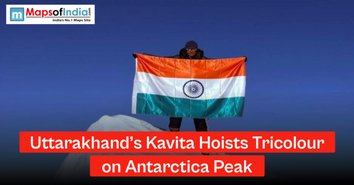 Uttarakhands Kavita A woman standing on a snowy Antarctic peak holding the Indian national flag, with a headline reading “Uttarakhand’s Kavita Hoists Tricolour on Antarctica Peak” and Maps of India logo.