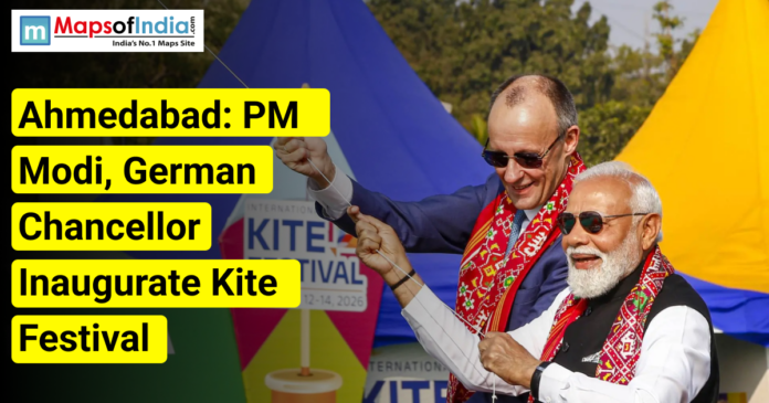 Two political leaders flying kites at an outdoor event in Ahmedabad, with colorful kites in the background and on-image text announcing the inauguration of a kite festival, alongside the Maps of India logo.
