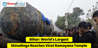 Bihar: World’s Largest Shivalinga Reaches Virat Ramayana Temple An image showing a massive, black stone Shivalinga being transported on a large trailer, surrounded by a crowd of people. Yellow text overlays read: "Bihar: World’s Largest Shivalinga Reaches Virat Ramayana Temple." The "Maps of India" logo is in the top left corner.