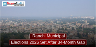 Ranchi Municipal Elections 2026 Set After 34-Month Gap An aerial cityscape view of Ranchi under a hazy sky, featuring a mix of low-rise buildings and greenery. A dark red banner in the foreground reads, "Ranchi Municipal Elections 2026 Set After 34-Month Gap," with a "Maps of India" logo in the top left corner.