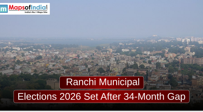 Ranchi Municipal Elections 2026 Set After 34-Month Gap An aerial cityscape view of Ranchi under a hazy sky, featuring a mix of low-rise buildings and greenery. A dark red banner in the foreground reads, "Ranchi Municipal Elections 2026 Set After 34-Month Gap," with a "Maps of India" logo in the top left corner.
