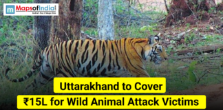 Uttarakhand to Cover ₹15L for Wild Animal Attack Victims A tiger walking through a forest in Uttarakhand with text stating “Uttarakhand to Cover ₹15L for Wild Animal Attack Victims” and the Maps of India logo.