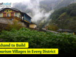 Scenic mountain village in Uttarakhand with traditional houses, lush green vegetation, and mist-covered hills, featuring a headline that reads ‘Uttarakhand to Build Two Tourism Villages in Every District.’