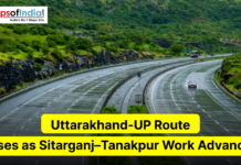 Uttarakhand-UP Route Eases as Sitarganj–Tanakpur Work Advances A scenic multi-lane highway curves through a lush, green hilly landscape under overcast skies. The image includes the Maps of India logo in the top left and a yellow headline reading "Uttarakhand-UP Route Eases as Sitarganj–Tanakpur Work Advances."