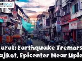 Busy street market in Rajkot, Gujarat, with shops, pedestrians, motorcycles, and signboards lining a narrow road, featuring a headline that reads ‘Gujarat: Earthquake Tremors Jolt Rajkot, Epicenter Near Upleta.’