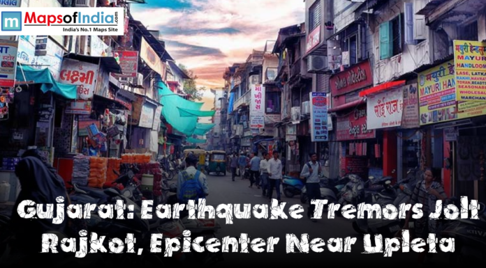 Gujarat: Earthquake Tremors Jolt Rajkot, Epicenter Near Upleta Busy street market in Rajkot, Gujarat, with shops, pedestrians, motorcycles, and signboards lining a narrow road, featuring a headline that reads ‘Gujarat: Earthquake Tremors Jolt Rajkot, Epicenter Near Upleta.’