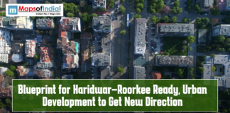 Blueprint for Haridwar–Roorkee Ready, Urban Development to Get New Direction Aerial view of a cityscape with roads, buildings, and green spaces, featuring text overlay “Blueprint for Haridwar–Roorkee Ready, Urban Development to Get New Direction” and the Maps of India logo.