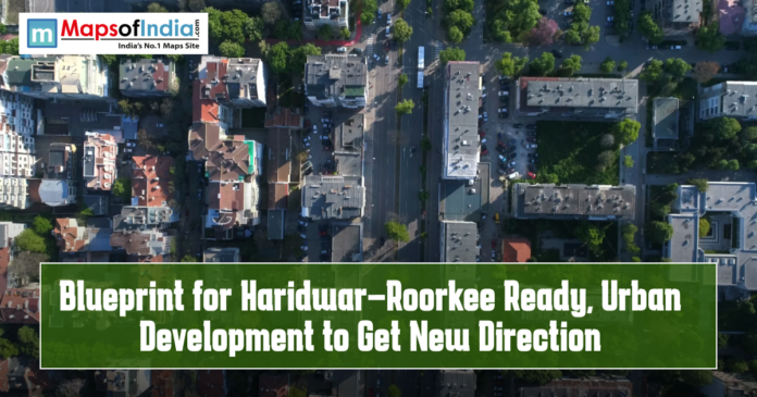 Aerial view of a cityscape with roads, buildings, and green spaces, featuring text overlay “Blueprint for Haridwar–Roorkee Ready, Urban Development to Get New Direction” and the Maps of India logo.