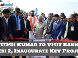 Bihar Chief Minister Nitish Kumar inaugurates a project by cutting a ribbon during an official event, surrounded by security and government officials.