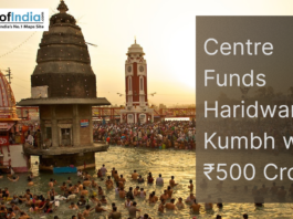 Devotees bathing in the Ganga at Haridwar during Kumbh Mela, with temples and clock tower in the background and text about ₹500 crore central funding