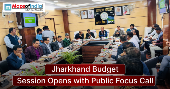 Officials attend a Jharkhand government budget meeting in a conference room, with a presentation screen and banner reading “Jharkhand Budget Session Opens with Public Focus Call.”