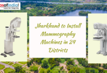 Jharkhand to Install Mammography Machines in 24 Districts Promotional graphic showing mammography machines on both sides with the headline “Jharkhand to Install Mammography Machines in 24 Districts” over an aerial cityscape background and Maps of India logo